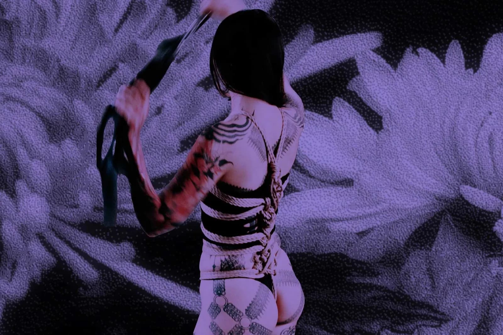 A tattooed figure tied in ropes wielding a flogger against a purple background with floral elements.