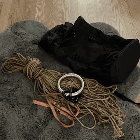 Rope bag contents including jute coils and bondage accessories.