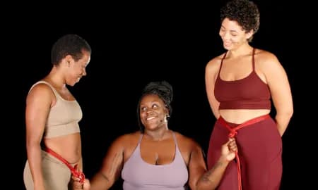 Three people demonstrate red rope bondage techniques.