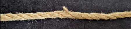 Close-up of jute rope showing broken and separated fibers.