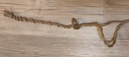 Rope laid on wood showing multiple twisted sections and areas of fiber loss.