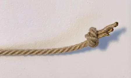 A beige synthetic rope with a tied knot at the end.