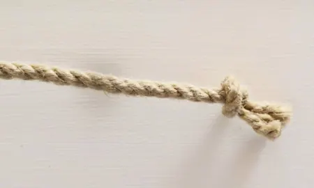 A tan synthetic rope with a knotted end.